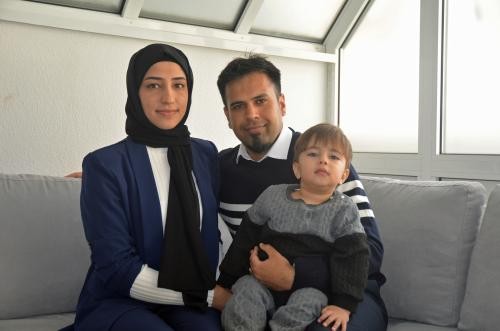 Raihana Ghafuri und Mohammad Akbar Mahmoody sitzen zusammen mit ihrem Sohn Ali Omer auf dem heimischen Sofa.