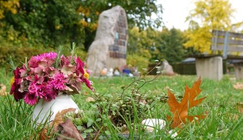 Baumbestattungen Der Gedenkstein mit Namenstafeln auf dem Leutesheimer Friedhof