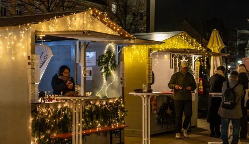 Beleuchtete Weihnachtsbuden stehen auf dem Marktplatz