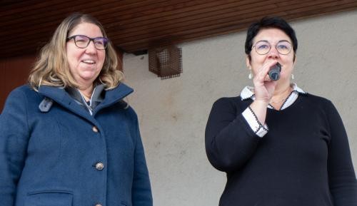 Monika Jauch und Anja Weinacker stehen nebeneinander. Anja Weinacker spricht in ein Mikrofon.