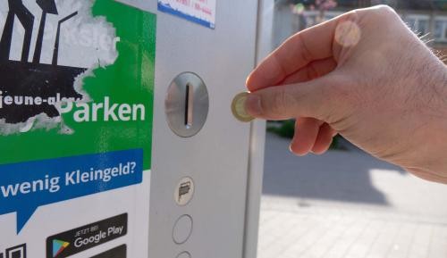 Münzeinwurf am Parkscheinautomaten auf dem Rathausareal